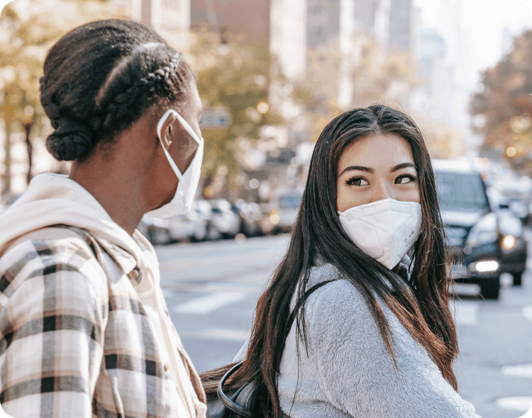 A photo of two happy persons wearing protective masks